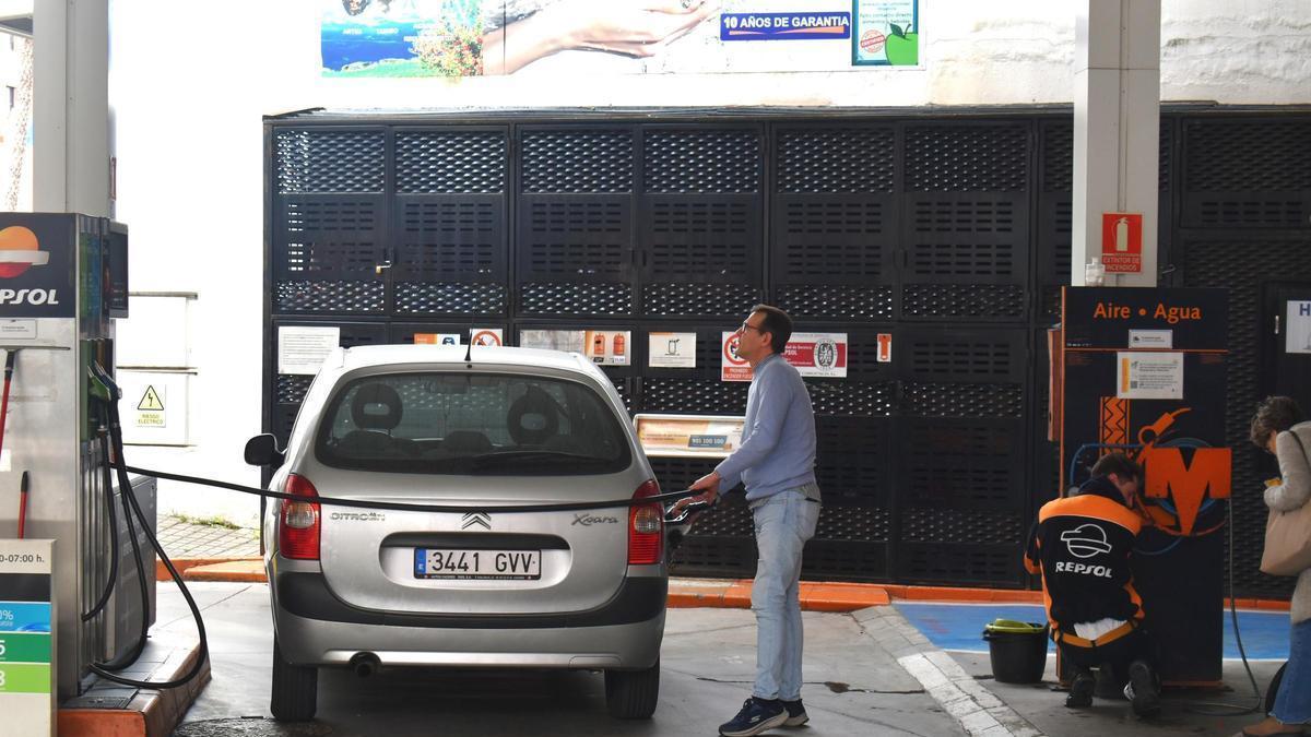 Un ciudadano repostando mientras observa el marcador en una gasolinera de Cáceres.
