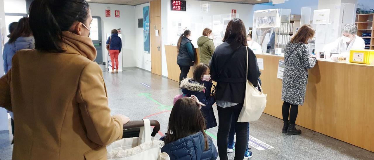 Personas haciendo cola para citas médicas en un centro de salud.