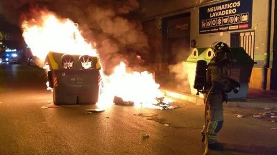 Efectivos de bomberos tratan de sofocar el incendio de contenedores esta madrugada en La Raya