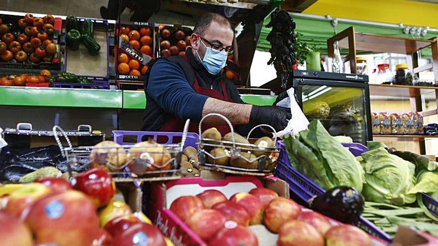 Marco Casas sirviendo naranjas, ayer, en su tienda de Noreña. 