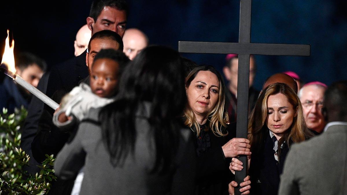 Una mujer ucraniana y una rusa sostienen la cruz durante el Via Crucis celebrado el Viernes Santo en Roma