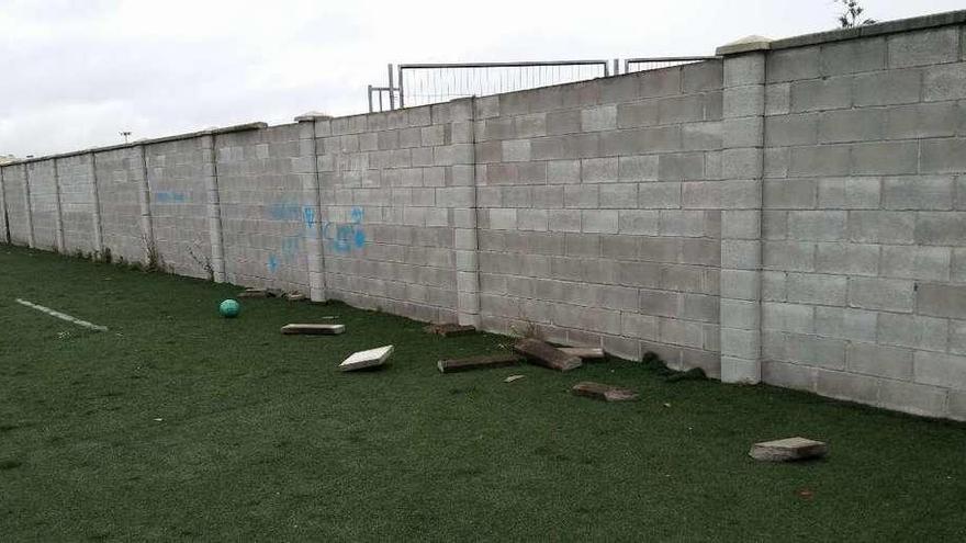 Daños en la parte superior de uno de los tramos del muro que separa la piscina del campo de fútbol.