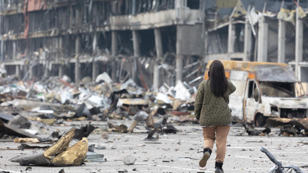 Una mujer hace una fotografía a un edificio destruído en la capital de Ucrania, Kiev.