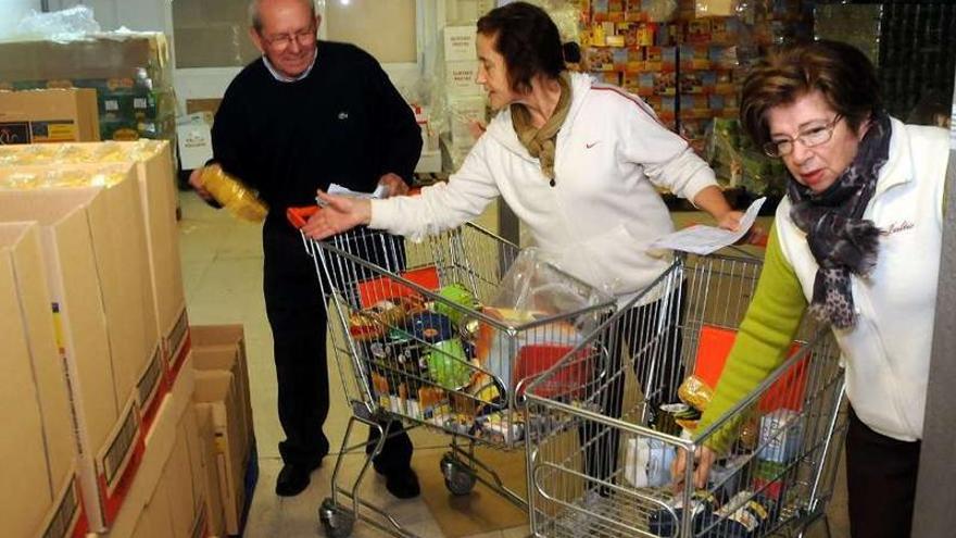 Voluntarios del Club de Leones clasifican alimentos donados para su posterior distrbución.