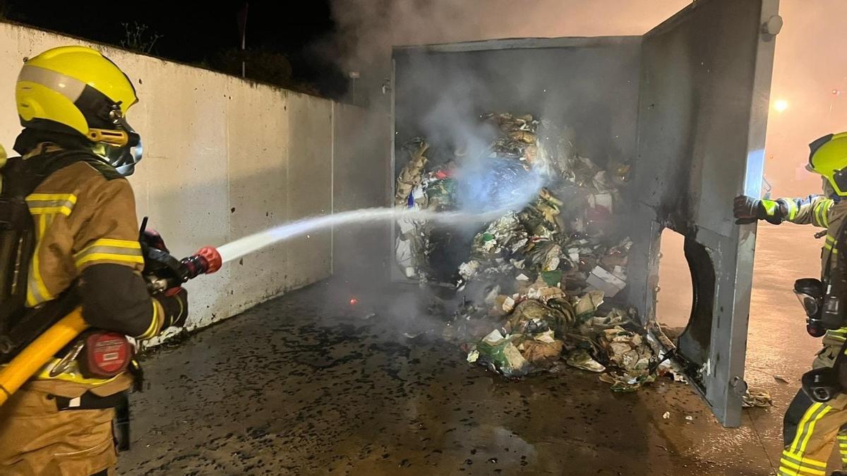 Los bomberos de la DPH apagando el incendio iniciado en la maquina plegadora carton.