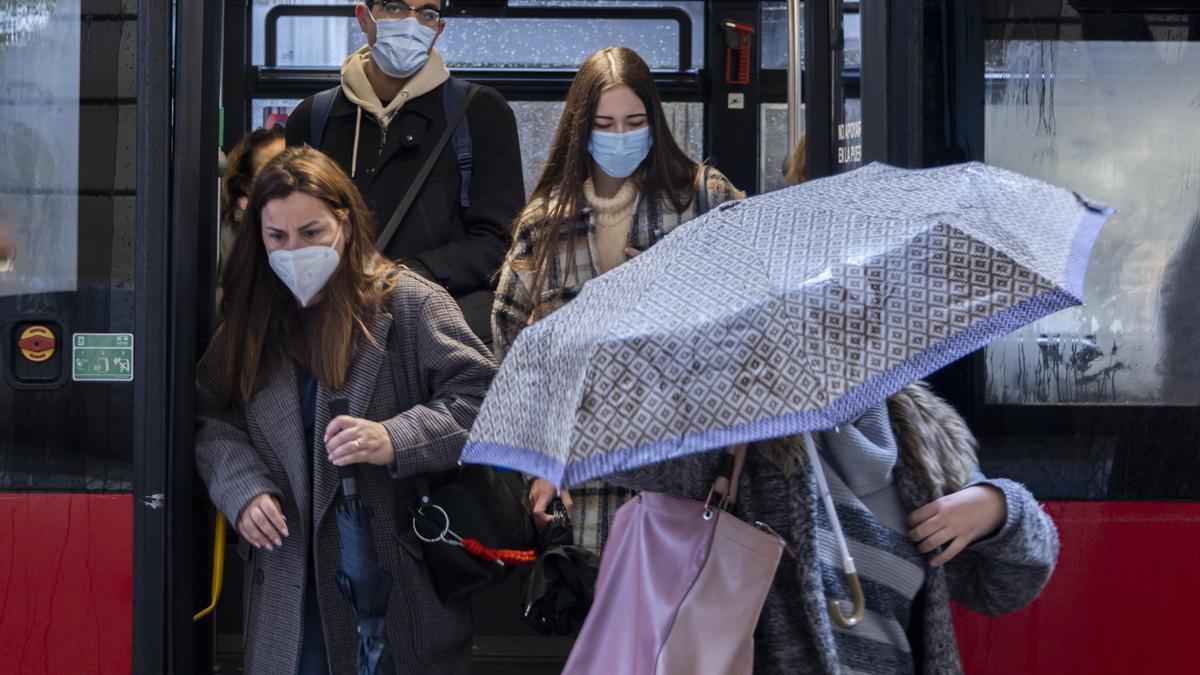 Personas con mascarilla bajan de un autobús de la EMT el primer día que no es obligatoria.