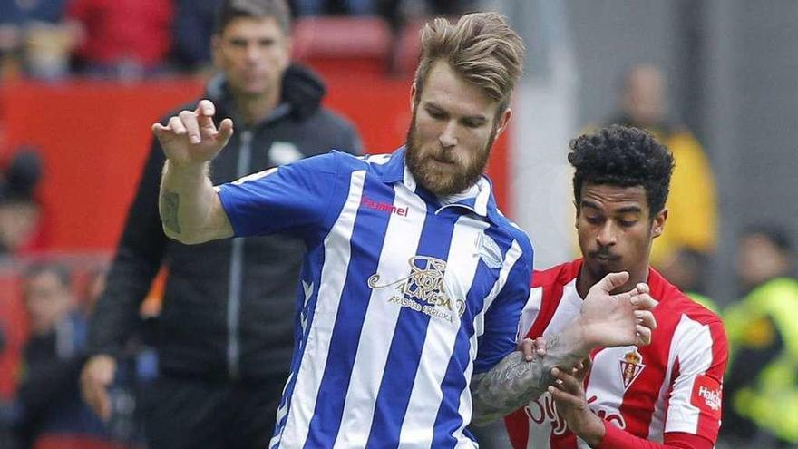 Katai, del Alavés, controla el balón ante el catarí Akram Afif, ayer en El Molinón. // Alberto Morante