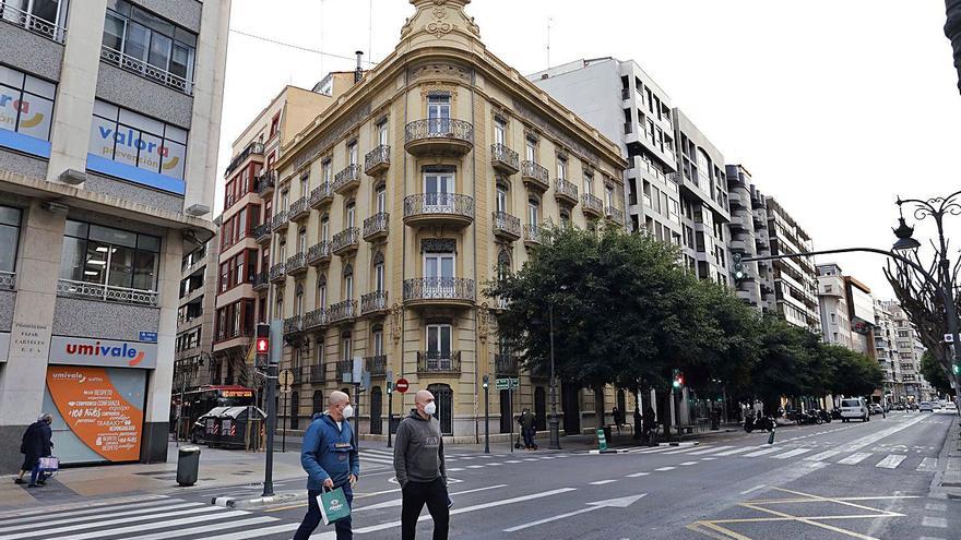 Dos hombres cruzan ayer la calle Colón con el edificio del Consell, de 638 metros, en la esquina. | MIGUEL ÁNGEL MONTESINOS