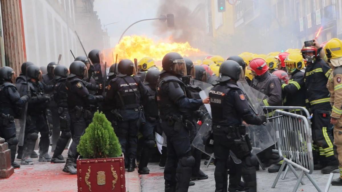 Momento del enfrentamiento entre bomberos y policías, a las puertas de la Diputación de Ourense, en el que se ve una llamarada.