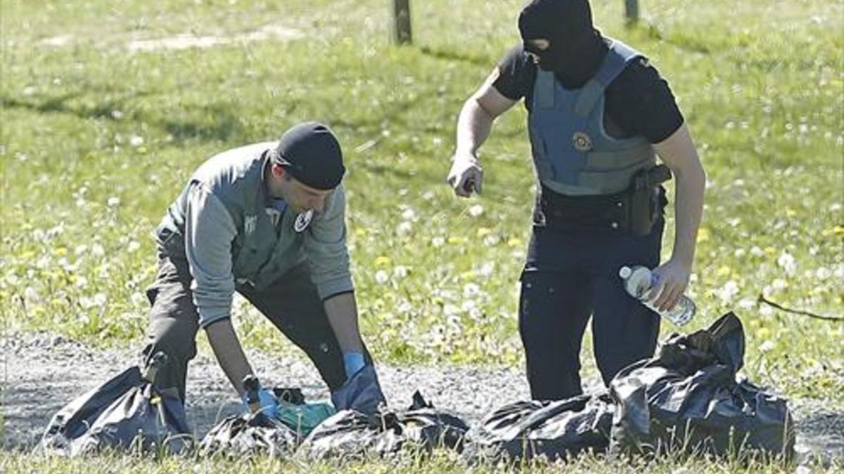 Policías franceses examinan las armas de uno de los zulos de ETA.