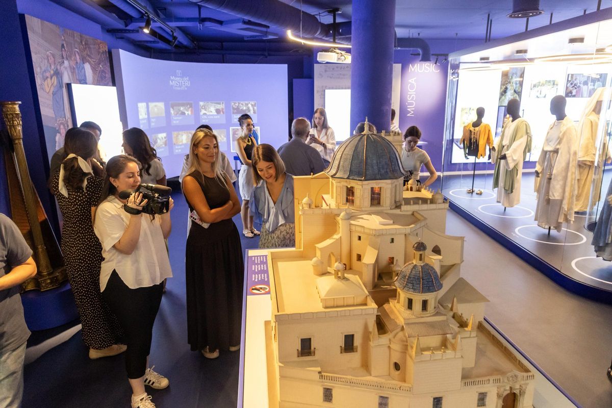 Maqueta de Santa María y, al fondo, trajes de los actores del Misteri en el renovado museo en Elche