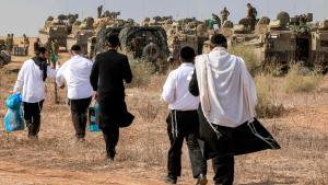 Un grupo de judíos ultraortodoxos visitan a soldados israelíes en la frontera con Gaza, el pasado 11 de octubre.