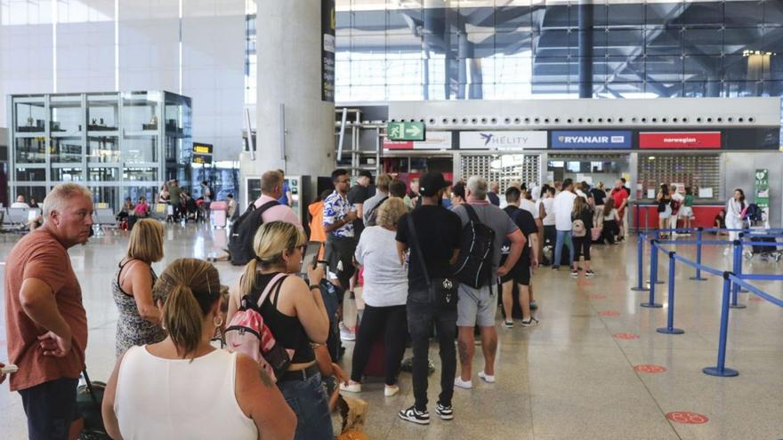 Pasajeros hacen cola en un mostrador de Ryanair, este domingo, en el aeropuerto de Málaga.