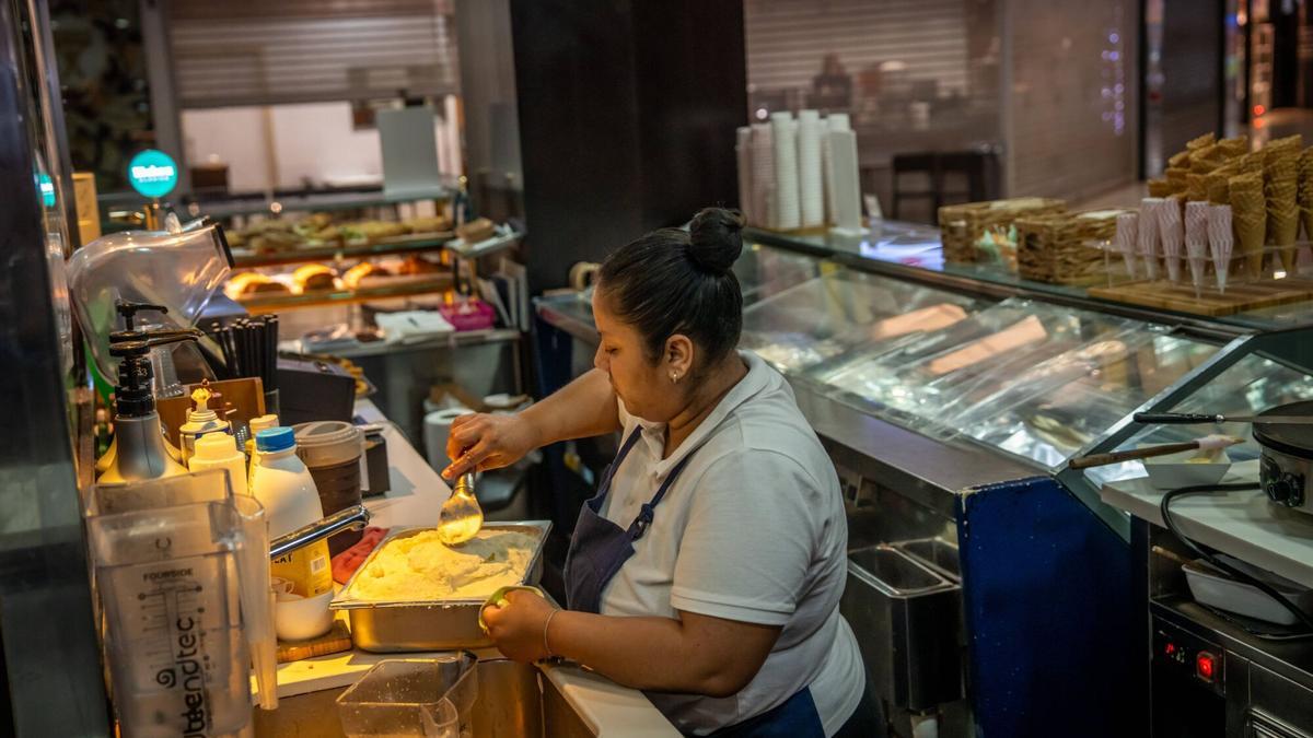 Una empleada recoge restos de comida estropeados durante el apagón del pasado lunes en un establecimiento de Barcelona.