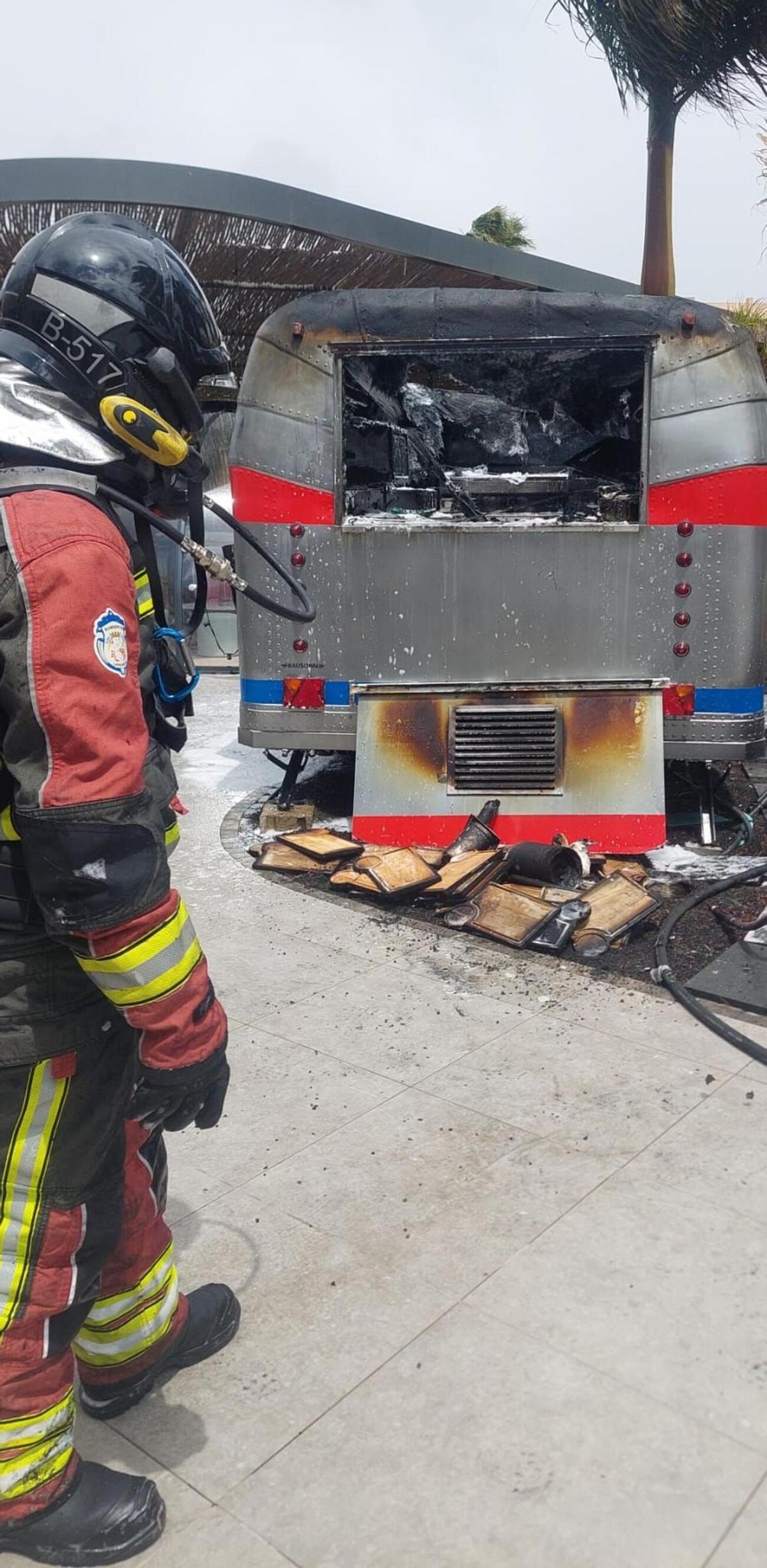 Un bombero del Consorcio de Seguridad y Emergencias de Lanzarote, ayer, jueves 9 de abril, junto a la caravana de comidas que ardió junto a un hotel en Costa Teguise, en Lanzarote