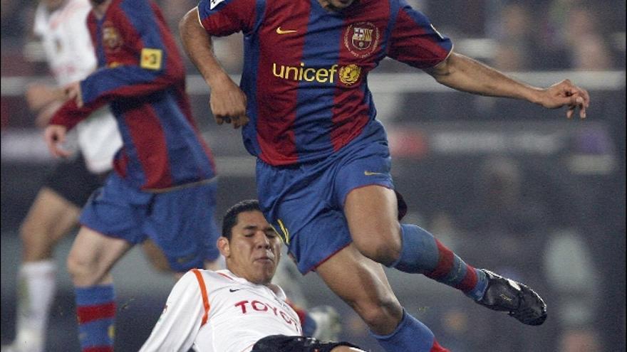 El delantero francés del FC Barcelona, Thierry Henry, intenta superar al jugador del Valencia CF, Maduro.
