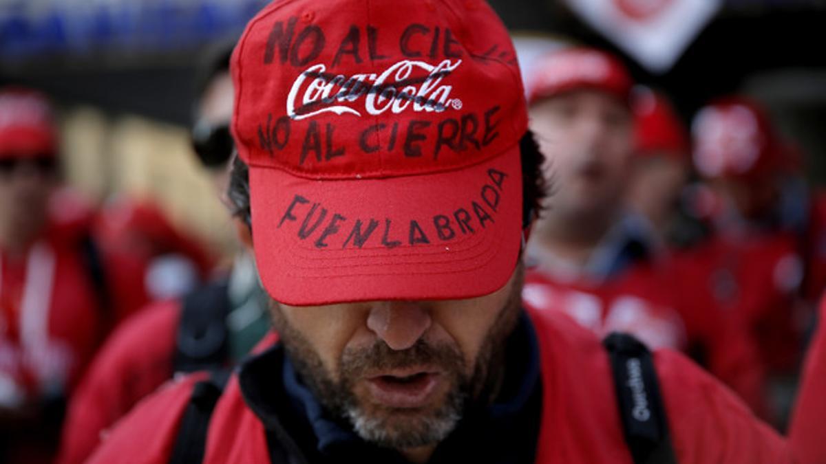 Trabajadores de Coca Cola protestan por el cierre de fábricas, frente a la sede del Partido Popular.