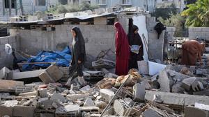 Unas mujeres inspecionan casas dañadas tras un bombardeo israelí en Rafah