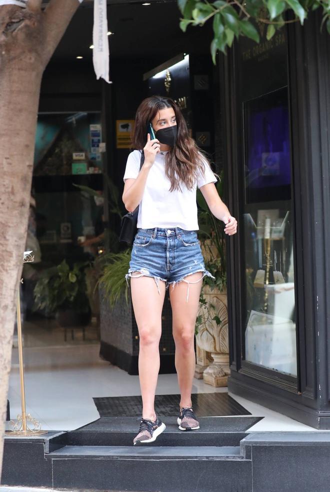 María Pedraza con camiseta blanca, pantalones cortos vaqueros y zapatillas