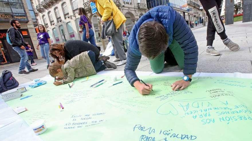 Varios niños participan en la creación de un mural a favor de la igualdad.