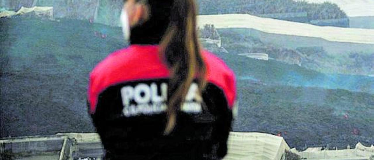 Una agente de policía ejerce labores de vigilancia durante los primeros momentos de la erupción volcánica.