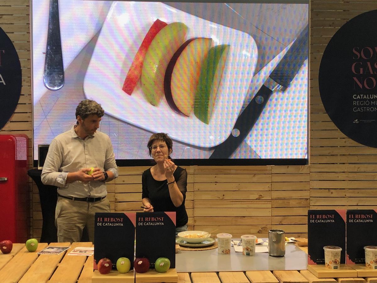 Empar Moliner tasta les pomes de Girona que Jaume Armengol va portar al Forum.