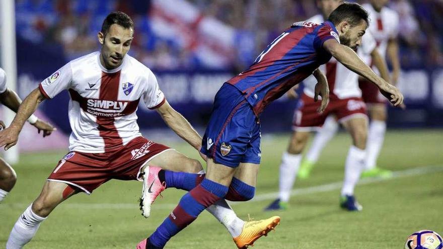 Ferreiro, del Huesca, hace una falta al jugador del Levante durante el partido del Ciutat de Valencia. // Efe