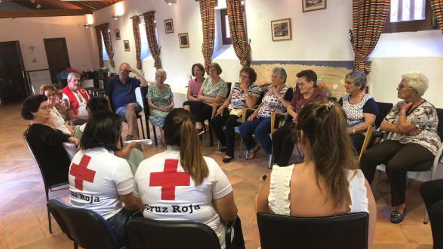 Personal de Cruz Roja, junto a un grupo de personas mayores usuarias del servicio.