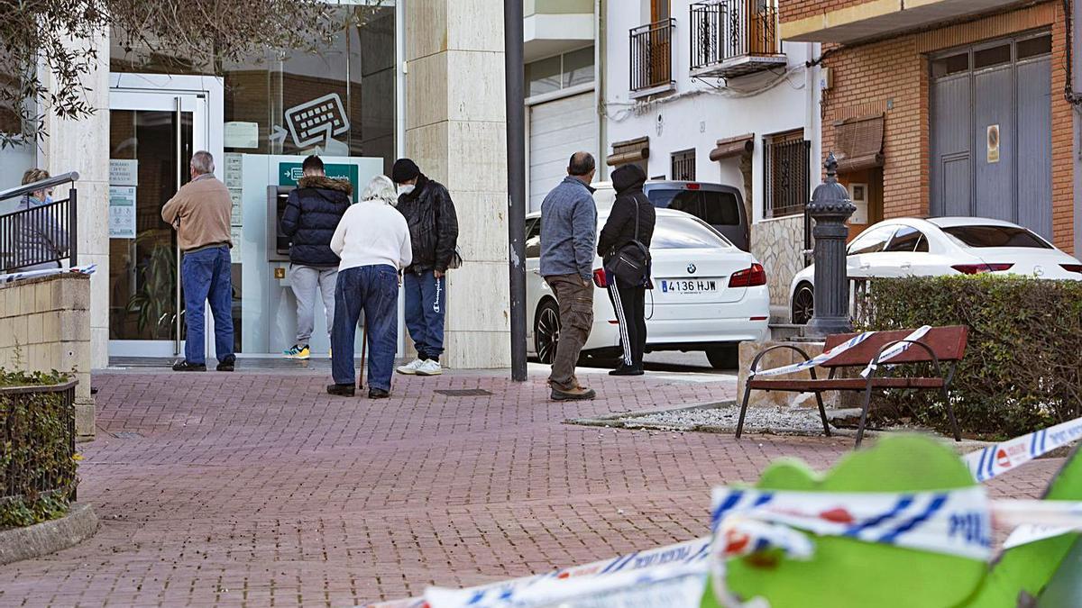 Veïns d’Anna fan cua en un caixer automàtic, amb un parc precintat davant | PERALES IBORRA