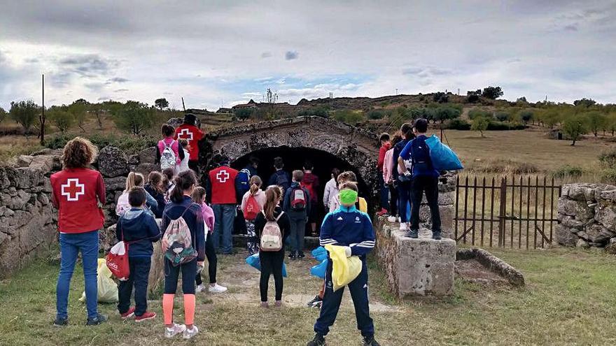 Los escolares junto a voluntarios de Cruz Roja en una fuente del entorno de Fermoselle. | Cedida