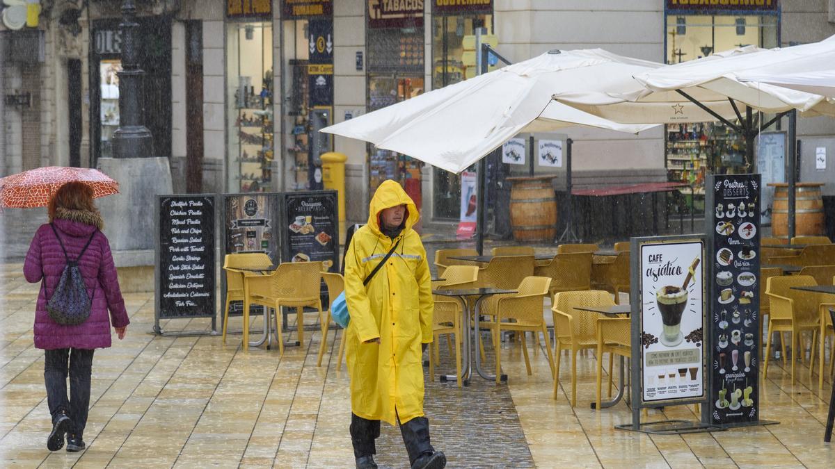 Un hombre con chubasquero por las calles de Cartagena ante un episodio de fuertes lluvias
