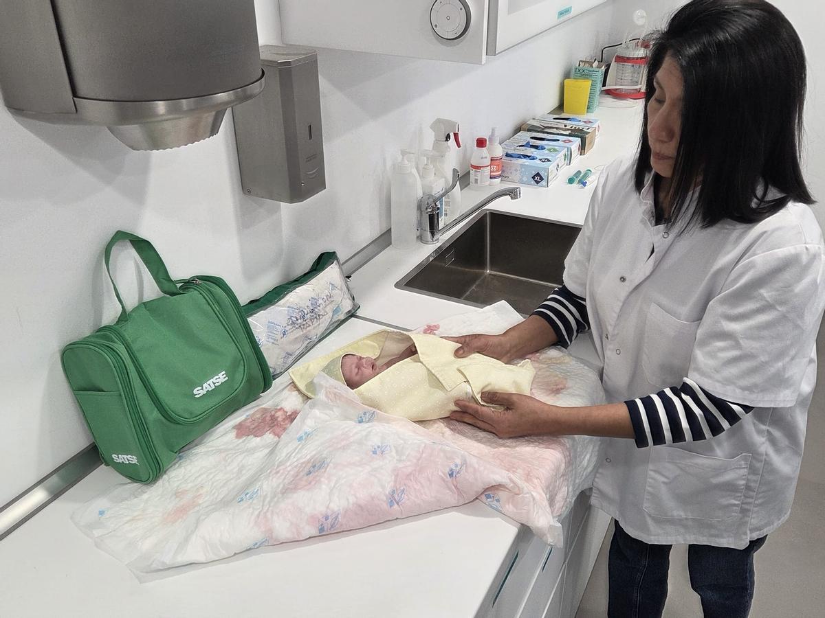 Una matrona practica cómo envolver al bebé con el arrullo en una sesión de simulación en la sede de SATSE.