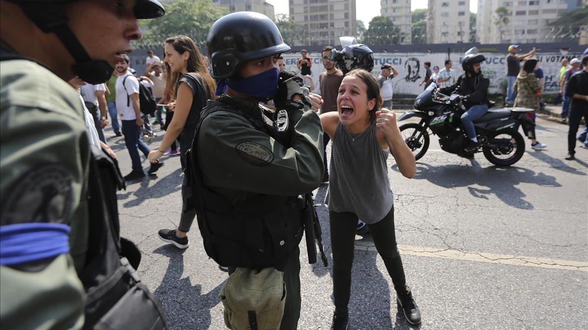 Una mujer aplaude a los soldados rebeldes que se alzan contra el gobierno del presidente de Venezuela, Nicolás Maduro, frente a la base militar de La Carlota.