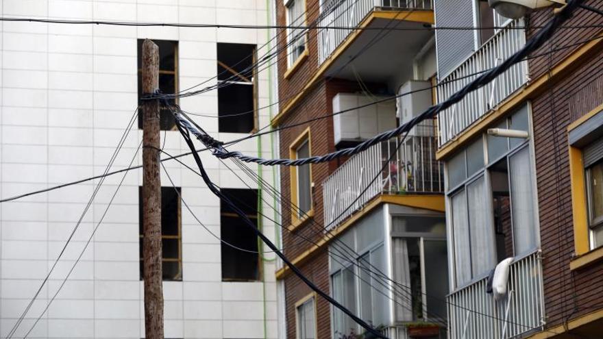 Un poste sujeta un montón de líneas y cables en la calle Trovador de Zaragoza.