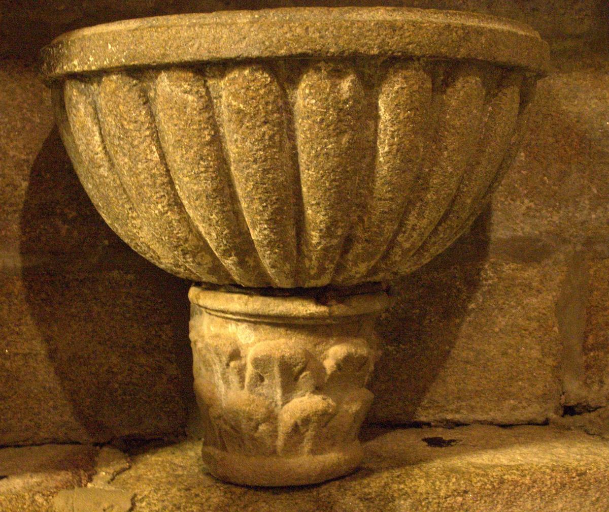 Capitel, posiblemente prerrománico, que soporta a pía de auga bendicida do século XVI.
