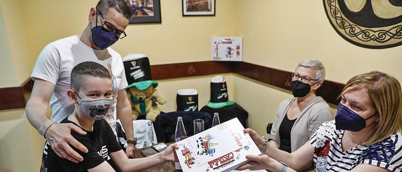 Raúl Alba y su hijo Miguel recogen el libro “Too Castañón” en el Café Trisquel, ayer.