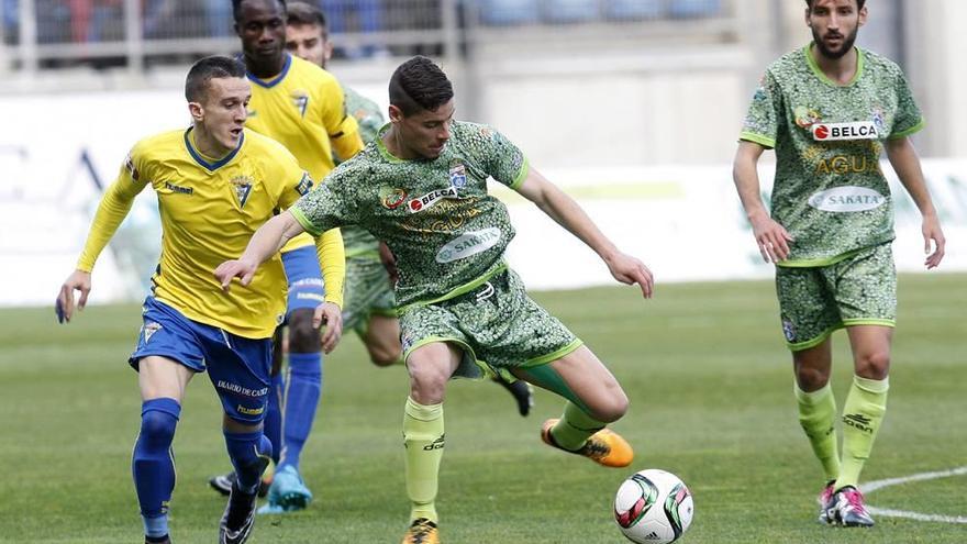 Roberto Alarcón, de La Hoya Lorca, avanza con el balón perseguido por un jugador del Cádiz durante el partido de  ayer.