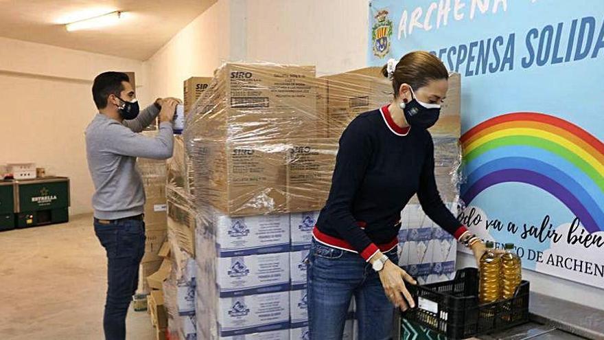 Dos personas guardan algunos de los alimentos.