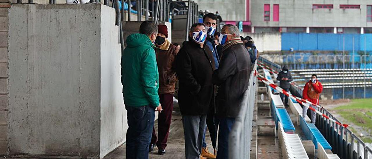 En la imagen de arriba, el colegiado se dispone a coger el balón poco antes de aplazar el partido; debajo, los espectadores esperan a ver si se reanuda el encuentro en el Suárez Puerta. | Mara Villamuza