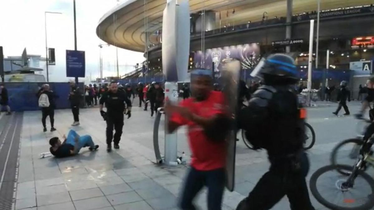 La policía interviene mientras los fanáticos trepan la valla del Stade de France antes del partido de fútbol final de la UEFA Champions League.