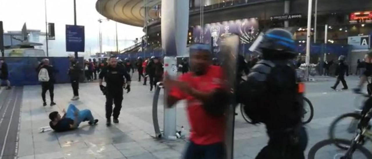 La policía interviene mientras los fanáticos trepan la valla del Stade de France antes del partido de fútbol final de la UEFA Champions League.