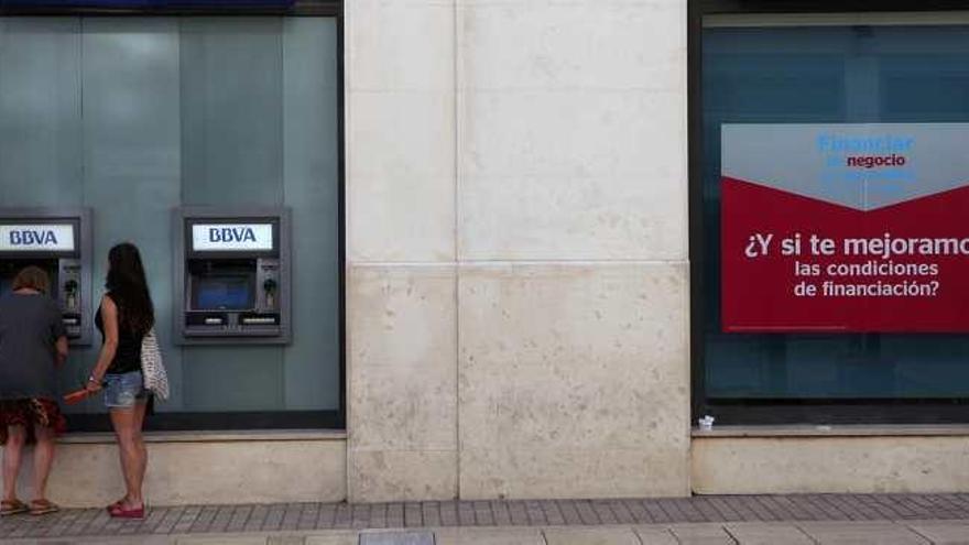 Dos mujeres en un cajero de una entidad bancaria situada en el Centro de la capital malagueña.