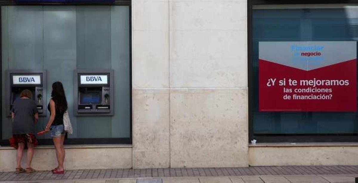 Dos mujeres en un cajero de una entidad bancaria situada en el Centro de la capital malagueña.