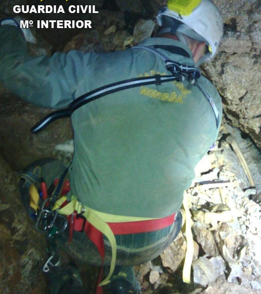 Un agente del GREIM junto a los restos hallados en la cueva de Tales.