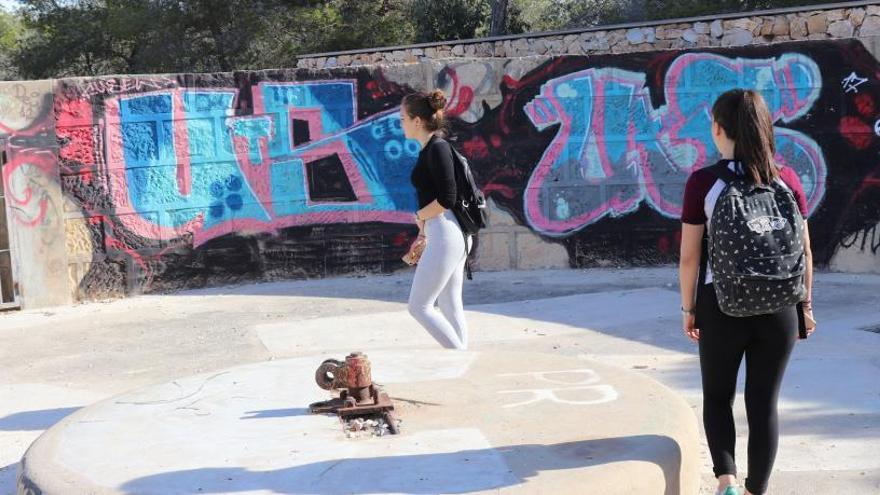 Dos adolescentes observan una de las tres baterías de costa de la II República llena de pintadas en la Sierra de Santa Pola.