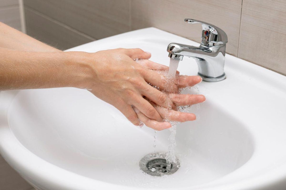 Una persona lavándose las manos en un baño
