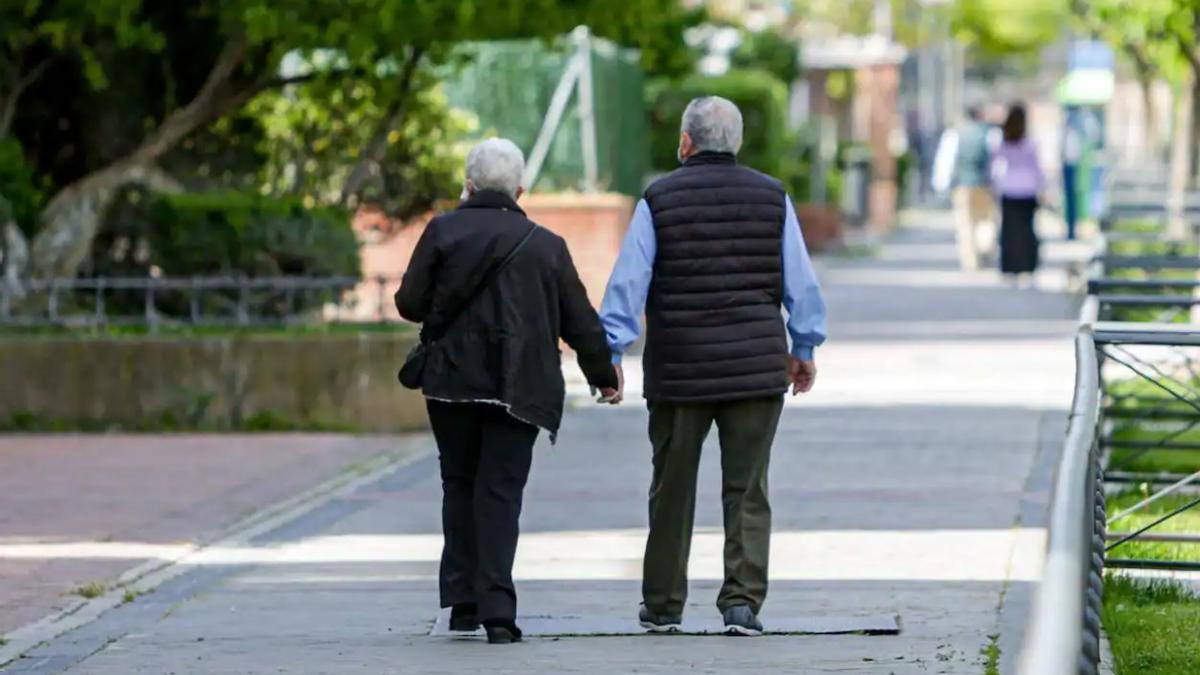 Dos jubilados pasean por la calle.