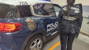 Archivo - Agente de la Policía Nacional junto a un vehículo