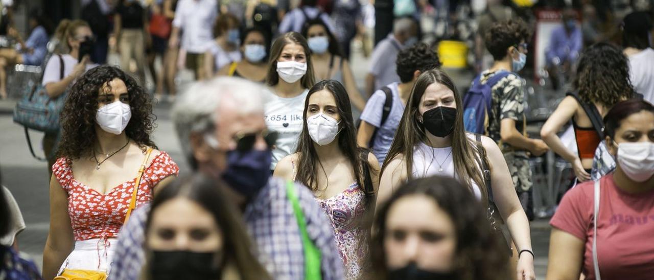 Personas pasean con mascarilla para evitar la expansión de la Covid-19