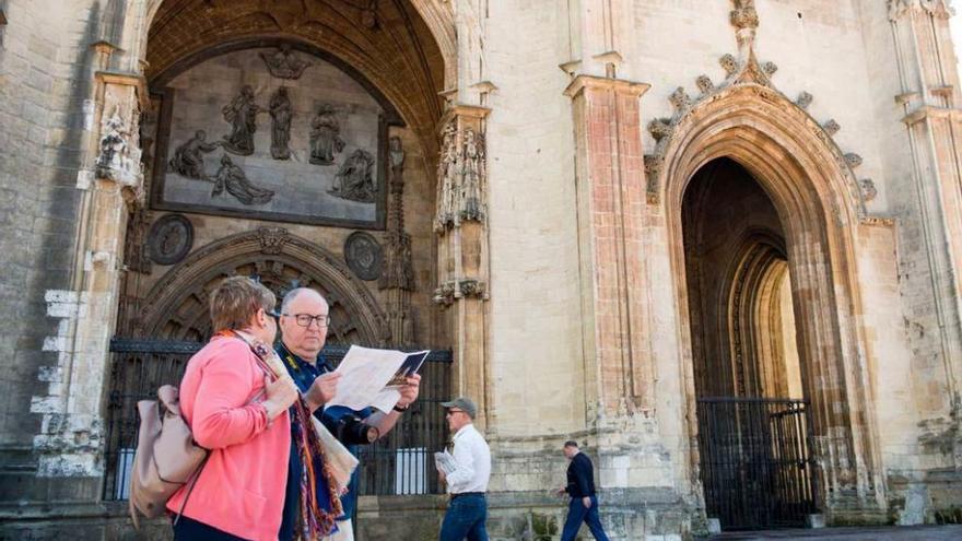 Una pareja consulta un folleto turístico ante la Catedral, el pasado domingo.